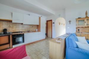 a living room with a blue couch and a kitchen at Casa Defrancesco - with Garden in Moena