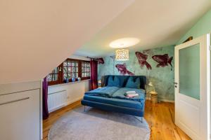 ein Schlafzimmer mit einem blauen Stuhl in einem Zimmer mit einer Wand, die mit Fischen verziert ist in der Unterkunft Sittermansweg in Geldern