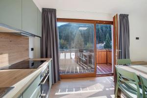 a kitchen with a large sliding glass door to a deck at Chalet Serenella in Valdidentro