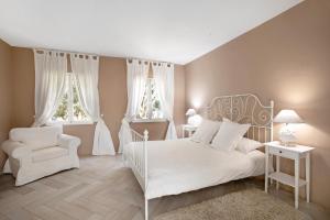 a white bedroom with a white bed and a chair at Saint Maxime in Adeje +20 photos