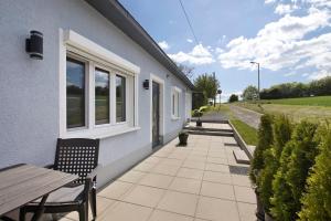 a patio with a wooden table and chairs next to a building at Ferienwohnung Pfauenhof in Harztor