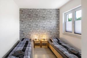 two beds in a room with a brick wall at Ferienwohnung Pfauenhof in Harztor