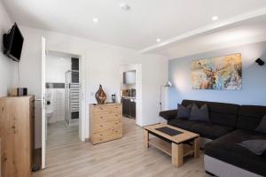 a living room with a couch and a kitchen at Ferienwohnung Pfauenhof in Harztor