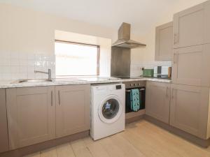 a kitchen with a washing machine and a sink at Daisy Nook in Hull