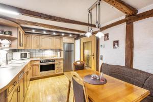 a kitchen with wooden cabinets and a wooden dining table at Ferienhaus Neuenrade in Neuenrade +17 photos