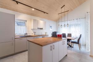 a kitchen with white cabinets and a wooden counter top at Im Rosengarten 3 in Zell am Harmersbach