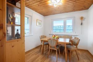 a dining room with a wooden table and chairs at Familie Quednow - Im Algi in Görwihl