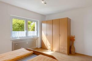 a bedroom with a large wooden cabinet and a window at Ferienwohnung Eva in Grebenhain