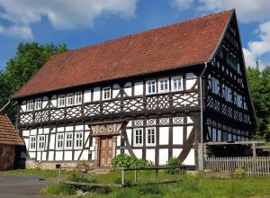 a black and white building with a brown roof at Ferienwohnung Eva in Grebenhain