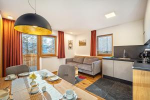 a kitchen and a living room with a table and a dining room at App Hubertus - Sonnklar in Sand in Taufers