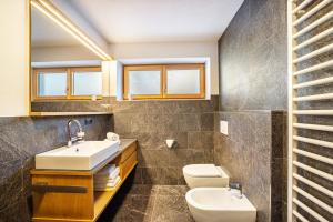 a bathroom with a sink and a toilet at App Hubertus - Sonnklar in Sand in Taufers +17 photos