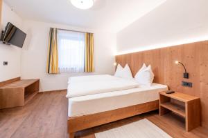a bedroom with a large bed with a wooden headboard at App. Miara - Ciasa Lavarella in San Vigilio Di Marebbe