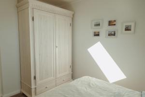 a bedroom with a bed and a white cabinet at Gästehaus Bröcker Wohnung 7 in Büsum