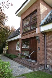 a brick house with a door with a bench in it at Gästehaus Bröcker Wohnung 7 in Büsum +10 photos