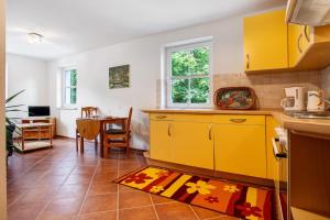 a kitchen with yellow cabinets and a table at Haus Seeadler Wohnung 11 in Koserow +26 photos