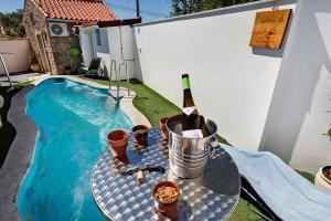 a bottle of wine on a table next to a swimming pool at Ninho do Rei in Fátima