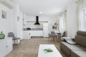 a white living room with a couch and a table at Apartamento Perez Zara 3 in Conil de la Frontera