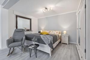 a bedroom with a bed and a chair at Ferienwohnung an der Volme in Meinerzhagen