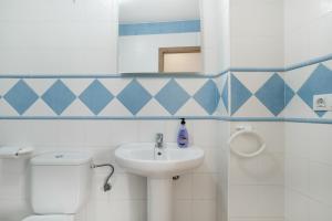 a bathroom with a toilet and a sink at Apartamento Perez Zara 3 in Conil de la Frontera +17 photos