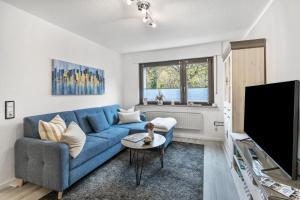 a living room with a blue couch and a tv at Ferienwohnung an der Volme in Meinerzhagen
