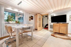 a dining room with a table and a tv at Haus Erna am Deister Apartment in Barsinghausen