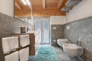 a bathroom with a toilet and a sink and a tub at La Villa di Ludo in San Cassiano +53 photos