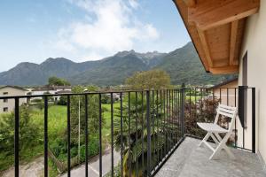 a white chair on a balcony with mountains in the background at La Villa di Ludo in San Cassiano