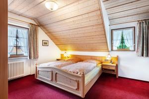 a bedroom with a bed and two windows at Cafe-Restaurant-Gästehaus Waldvogel in Feldberg