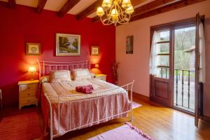 a bedroom with red walls and a bed and a window at Matxingonea 2 in Urdax