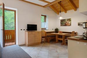 a kitchen and dining room with a table and a television at Altebnerhof Leifers in Laives