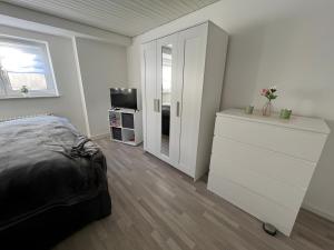 a bedroom with a bed and a dresser and a television at Petit Bijou in March +9 photos