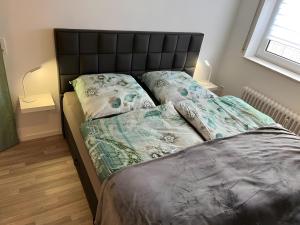 a bed with two pillows on it in a bedroom at Petit Bijou in March