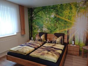 a bedroom with two beds and a painting on the wall at Haus Nietmann_ Ferienwohnung 2 in Altenau