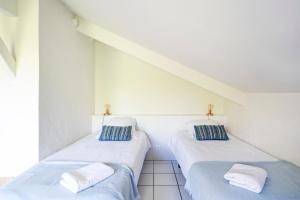 two beds in a room with white walls at Dune Lodge 2- Capbreton Hossegor - in Capbreton