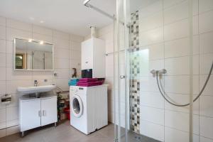 a bathroom with a washing machine and a sink at Bungalow Bei Rügen in Sundhagen-Niederhof +14 photos