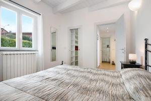 a white bedroom with a large bed and windows at Casa mare montaretto 1 in Bonassola