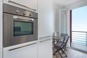 a kitchen with white cabinets and a table with chairs at Casa mare montaretto 1 in Bonassola