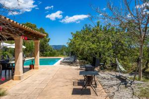 eine Terrasse mit Swimmingpool und Hängematte neben einem Haus in der Unterkunft Finca Moscari in Moscari