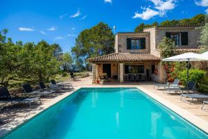 eine Villa mit Swimmingpool vor einem Haus in der Unterkunft Finca Moscari in Moscari