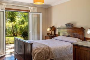 a bedroom with a bed and a sliding glass door at Villa Echium T1 in Caniço
