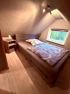 a small bed in a room with a window at Alte Schmiede in Melzow