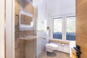 a bathroom with a shower and a toilet and a sink at Ferienhaus Wiese in Schmallenberg +34 photos