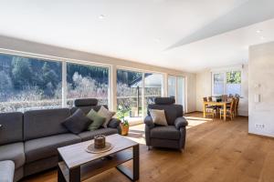 a living room with a couch and chairs and a table at Ferienhaus Wiese in Schmallenberg