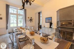 a dining room with a table and a fireplace at Château De Saint Mayeul in Joze