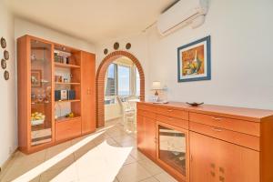 a kitchen with wooden cabinets and an arched window at Sea Views Centro Internacional A99 in Torrox +18 photos