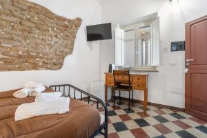 a bedroom with a bed and a desk and a mirror at Luxar Suites and Apartments in Assemini