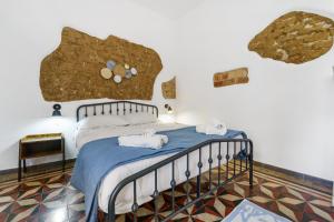 a bedroom with a bed with towels on it at Luxar Suites and Apartments in Assemini