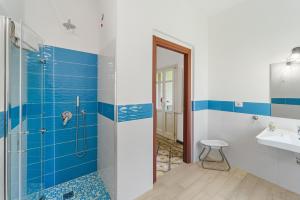 a blue and white bathroom with a shower and a sink at Luxar Suites and Apartments in Assemini +132 photos