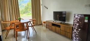 a living room with a small table and a television at Grace Hill Villa Lubuk Minturun in Padang