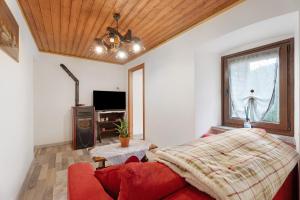 a living room with a red couch and a window at Casa del sole in Toceno